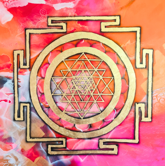 Goldene Sri Yantra auf einem bunten Hintergrund mit Orange-, Pink- und Rottönen, die geometrische und symmetrische Formen bilden.